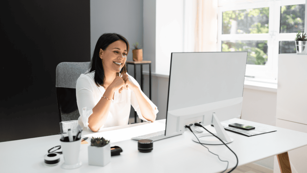 dark haired woman wearing white sitting at computer